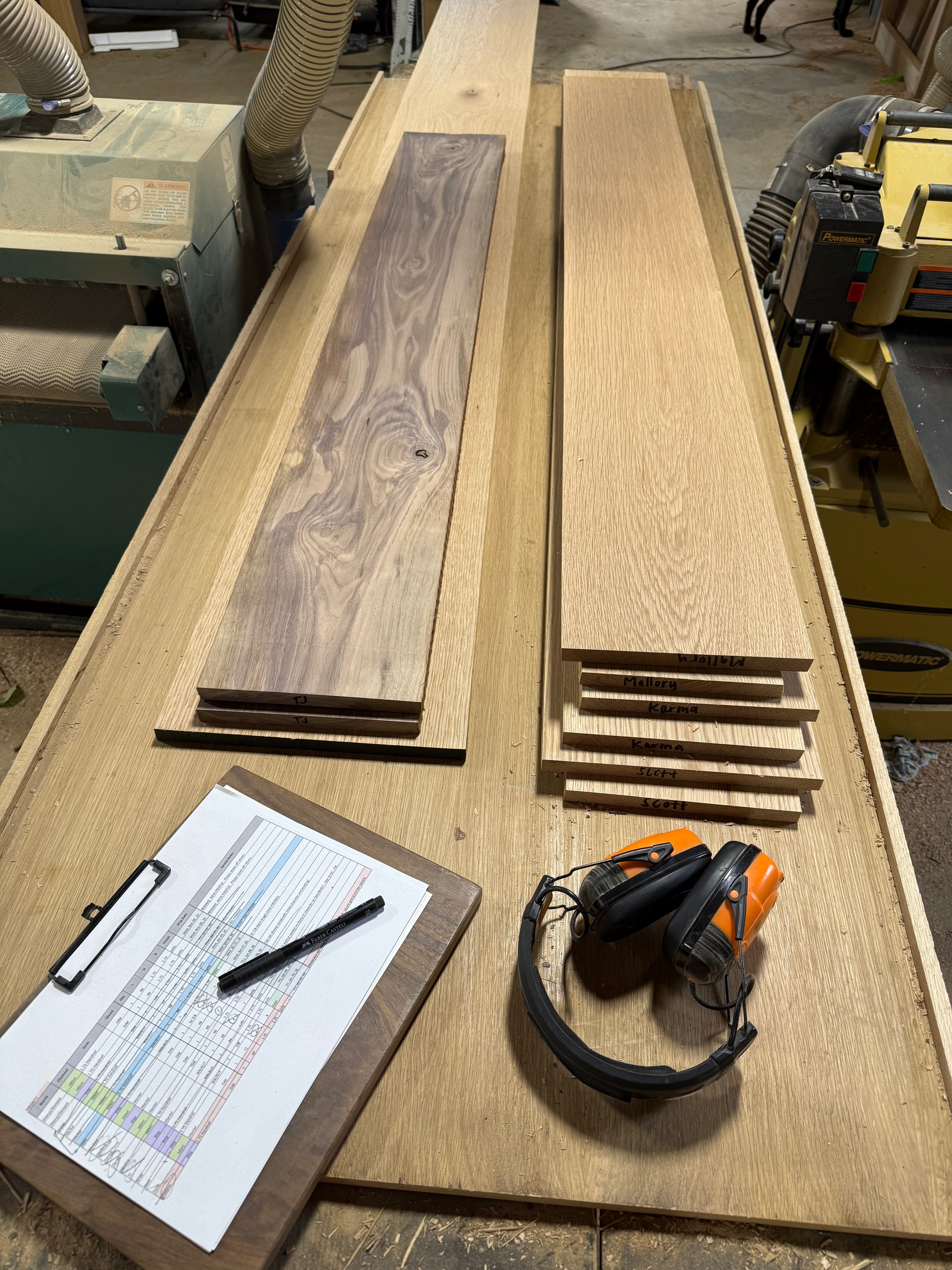 Dark walnut & white oak lumber freshly milled for mantel tops/bottoms. A list of orders & headphones for ear protection.