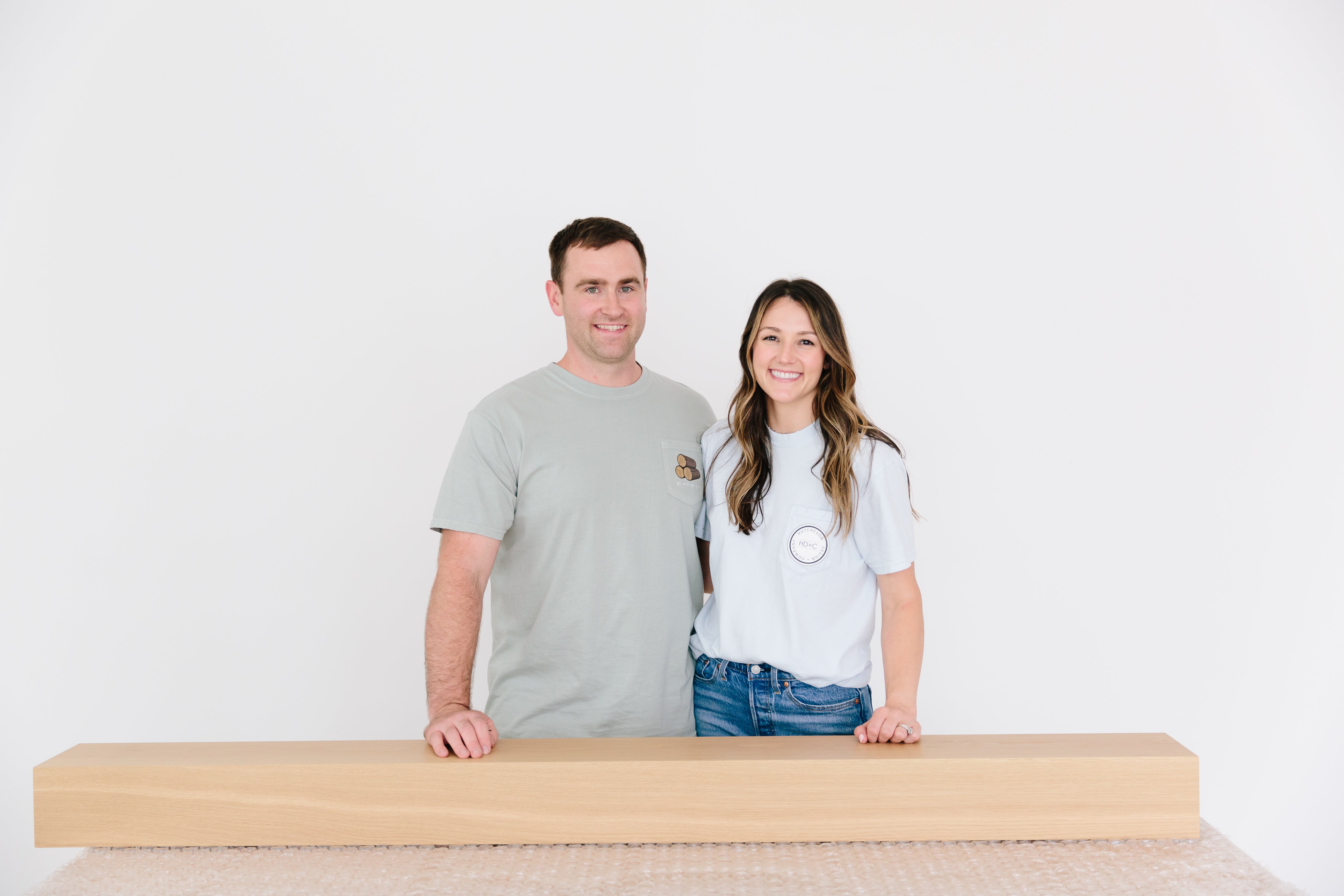 Matt + Hill with a white oak fireplace mantel sitting on bubble wrap, ready to pack for our customer.